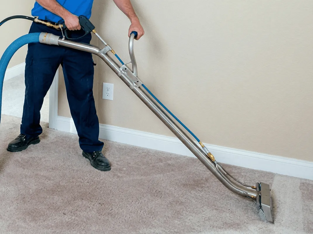 Professional operating a liquid removal machine on a carpeted floor in Albany, NY